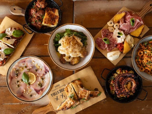 Mesa com carpaccio, bruschetta, focaccia, polvo e tábua de enchidos